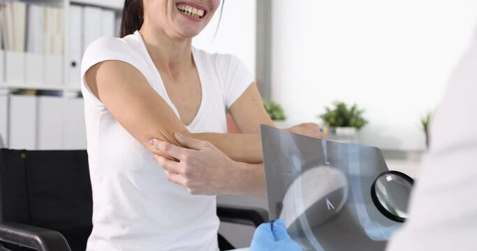 Doctor examines an x-ray of patient with elbow pain 4k movie