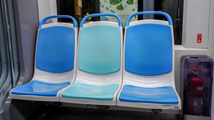The blue colored empty seats of a tram