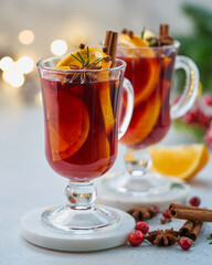 Two glasses of red mulled wine. Hot winter beverage with cinnamon, cardamom and clove, orange and...