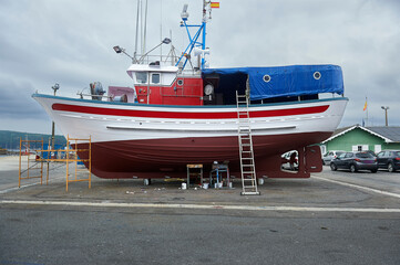 small fishing boat in dry dock to be cleaned and fixed