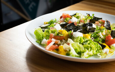 Delicious rice salad with lettuce, tomato, escarole and seaweed. Gourmet salad with natural products.
