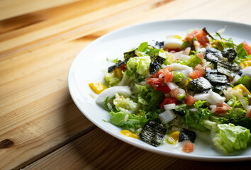Delicious rice salad with lettuce, tomato, escarole and seaweed. Gourmet salad with natural products.