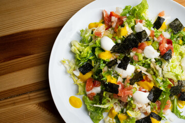 Delicious rice salad with lettuce, tomato, escarole and seaweed. Gourmet salad with natural products.