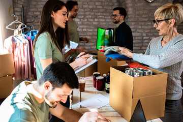 Group of volunteers working in community charity donation center.	