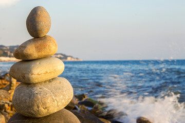 Balanced stones on the seashore summertime and sea background