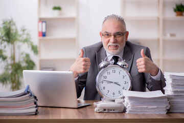 Old male employee in time management concept