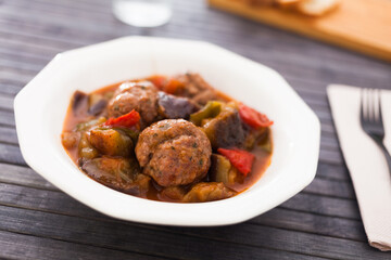 cooked meatballs with stewed eggplant in bowl