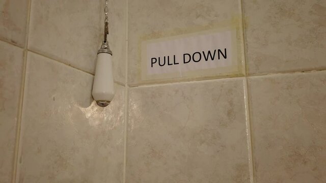 4K video of a hand pulling the toilet flush chain