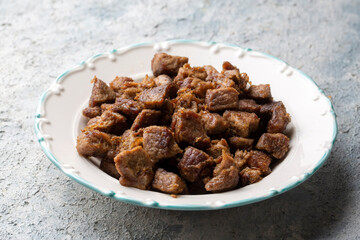 Muslims Traditional Sacrifice holiday food lamb, Turkish roasted meat in copper pot on table top. Turkish Kavurma.