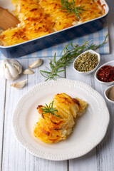 Potato gratin - graten (baked potatoes with cream and cheese) with rosemary and forks (Turkish name; Kremali patates)