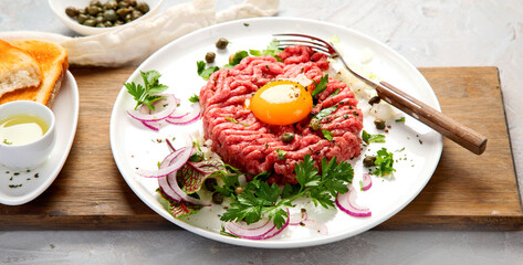 Beef steak tartare on light background. French cuisine concept.
