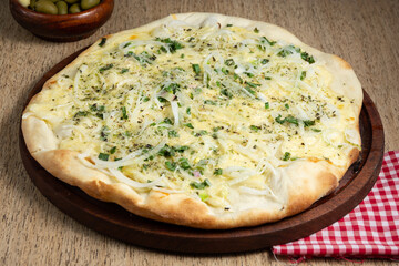 pizza de cebolla y verdeo con queso derretido recien horneada