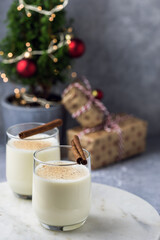 Christmas festive milk drink eggnog with cinnamon and nutmeg on a marble stand