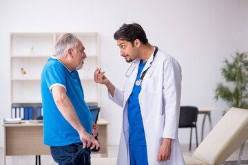 Fototapeta premium Old male patient visiting young male doctor