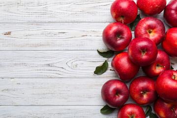 Fresh red apples with green leaves on wooden table. On wooden background. Top view free space for text