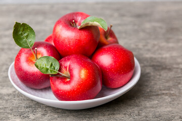 juicy red apples in a bowl or plate on the table top view. Copy space