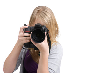Young teenage girl holding a digital camera and taking a photo. Isolated on white.