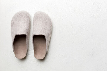 Warm winter women woolen slippers on colored background. Copy space for text - obrazy, fototapety, plakaty