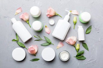 Composition with cosmetic products and beautiful roses on cement background. Flat lay