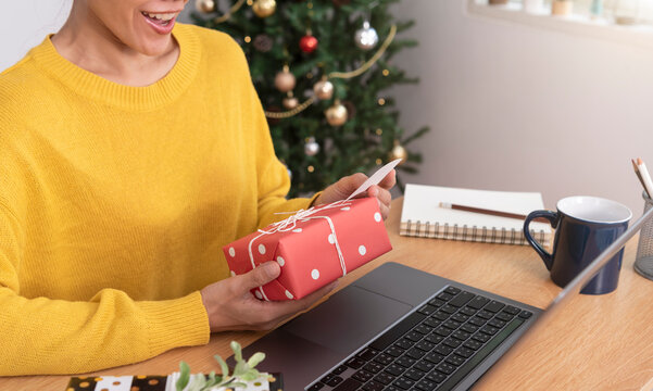 business woman holding giftbox and greeting card on office table in Christmas day.