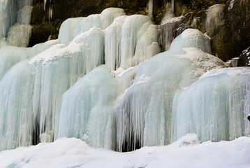 Frozen waterfall with huge beautiful icicles hanging from the rocks