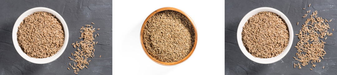 Set of spices cumin seeds (cuminum), jeera in white ceramic bowl on black concrete background, wooden bowl on white