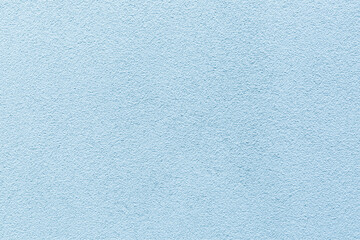 Sample of a texture of blue plaster. Wall finished with a decorative cement stucco. Example of exterior building decoration. Clean uniform grainy background. Banner. Wallpaper. Copy space. Pattern