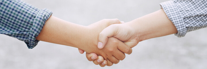 Closeup of a business hand shake between two colleagues Plaid shirt