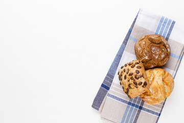 Gold rustic crusty loaves of bread and buns on wooden background. Still life captured from above top view, flat lay.