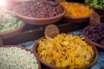 Dried fruits in plates in the market. Sweet healthy food