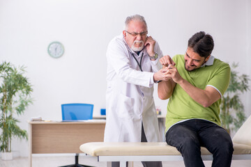 Young man visiting old male doctor