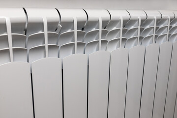 Central heating system. Modern radiator on white wall indoors.