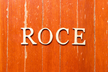Alphabet letter in word ROCE (Abbreviation of Return on Capital Employed) on old red color wood plate background