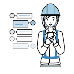 立ってスマートフォンで楽しくチャットで会話する工事現場の女性