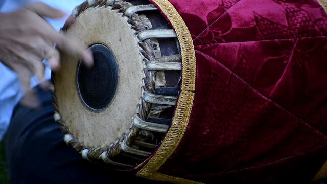 the video is a close up of a musician playing mridangam which is an indian percussion instrument