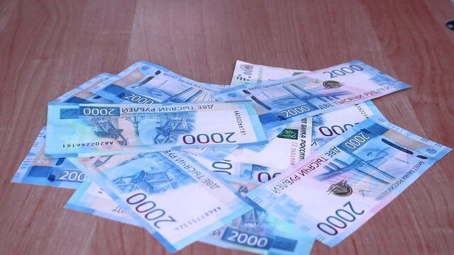 Timelapse - Russian money in 2000 and 5000 ruble bills fall on the table. Money background.