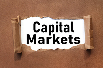 Capital Markets. Torn paper with space for text on brown background