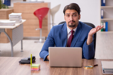 Young male employee sitting at workplace