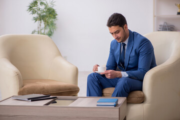 Young male employee waiting for business meeting