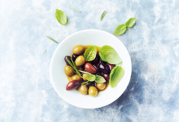 Green and kalamata olives on bright wooden background. Top view. Copy space.