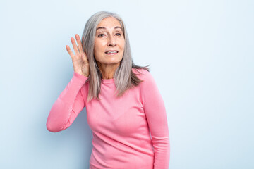 middle age gray hair woman looking serious and curious, listening, trying to hear a secret...