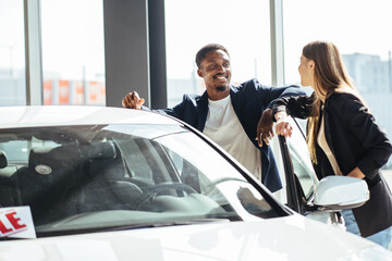 Multi ethnic couple examining various auto at showroom