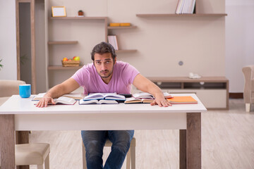 Young male student preparing for exams at home