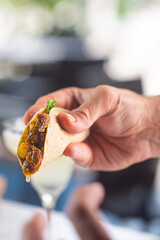 Sauce dripping out from Mexican food taco topped with a filling