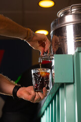 Barman pouring a vermut from a barrel into a glass