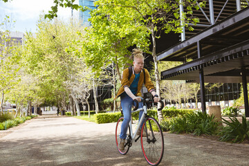 Thoughtful albino african american man with dreadlocks riding bike