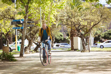 Thoughtful albino african american man with dreadlocks riding bike