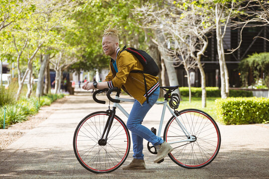 Portrait of smiling albino african american man with dreadlocks on bike