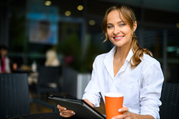 Fototapeta na wymiar Young businesswoman on a coffee break, smiling at camera