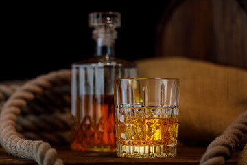 Glass and bottle of whiskey on rustic background